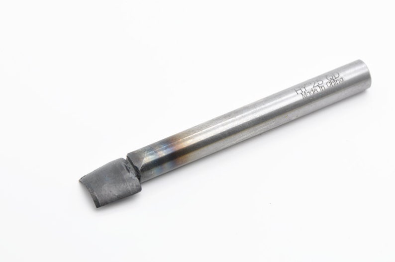 May include: A silver metal tool with a flat, angled tip and a cylindrical handle. The handle is marked with the text "HY-23 GD Made in China".