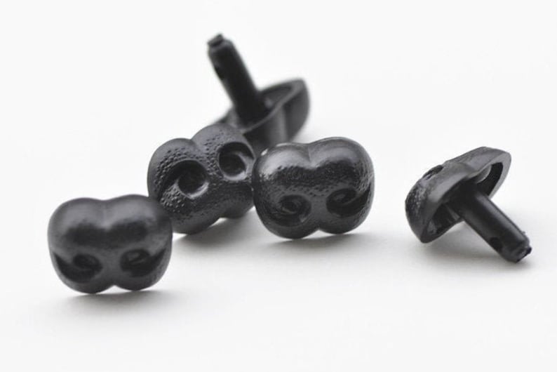 K&ouml;nnte beinhalten: Vier schwarze Plastikspielzeugaugen mit einer strukturierten Oberfl&auml;che und einem kleinen Loch auf der R&uuml;ckseite zum Befestigen. Die Augen sind so konzipiert, dass sie wie eine Cartoon-Tiernase aussehen.