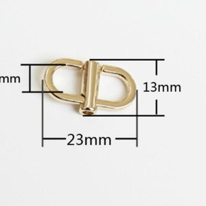 May include: Gold metal swivel hook with dimensions: 23 mm long, 13 mm wide, and 6 mm thick.