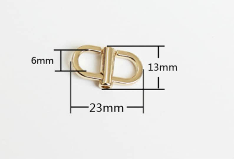 May include: Gold metal swivel hook with dimensions: 23 mm long, 13 mm wide, and 6 mm thick.