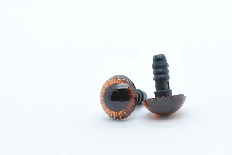 May include: Two brown plastic safety eyes with black plastic backs. The eyes are approximately 2.5 cm in diameter.