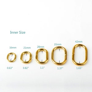 May include: Five gold-colored metal oval rings of different sizes. The rings are labeled with their inner size in millimeters and inches. The rings are arranged from smallest to largest.