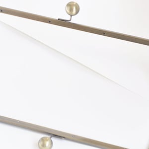 Può includere: Un telaio in metallo dorato per una borsa o una pochette. Il telaio ha due chiusure rotonde in metallo.