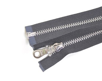 May include: A close-up of a black zipper with silver teeth. The zipper is open and the slider is visible.