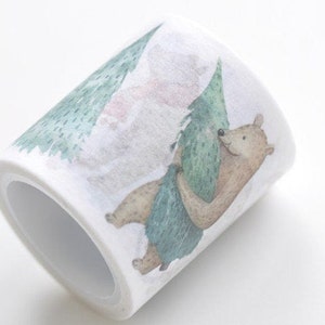 Puede incluir: Un rollo de cinta washi con una ilustración de acuarela de un oso sosteniendo un árbol verde. El fondo es blanco con un lavado de acuarela rosa claro y verde.