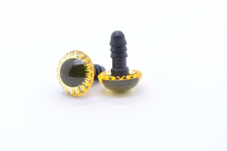 May include: Two yellow plastic safety eyes with black pupils and a black plastic post on the back. The eyes are designed for use in crafts and stuffed toys.
