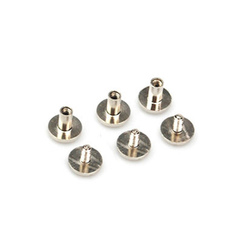 May include: Six silver metal screws with flat heads and a raised center. The screws are arranged in a semi-circle on a white background.