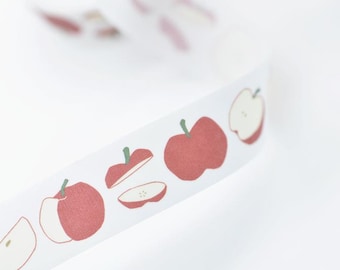 May include: White washi tape featuring a repeating pattern of red apples and apple slices with green stems. The tape is ideal for scrapbooking, crafting, and adding a decorative touch to various projects.