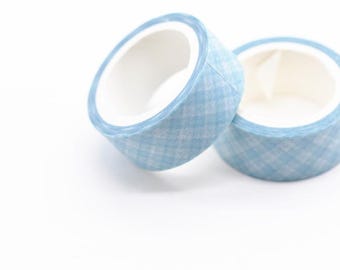 May include: Two rolls of light blue washi tape with a white and light blue plaid pattern. The tape rolls are on a white background. The tape is a decorative craft supply.