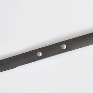 Puede incluir: Una correa de cuero negro con herrajes de metal dorado y remaches plateados. La correa está diseñada para ser utilizada como asa o correa de transporte.