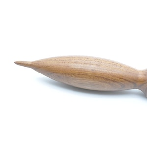 May include: A wooden massage roller with a rounded, pointed end and a textured, ridged handle.