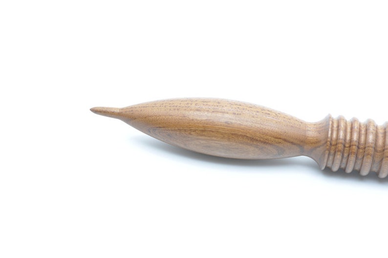May include: A wooden massage roller with a rounded, pointed end and a textured, ridged handle.