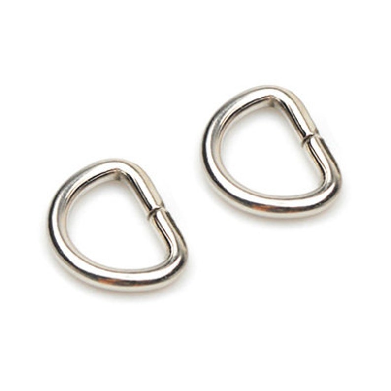 May include: Two silver D-rings, also known as key rings, are shown against a white background.