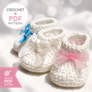 May include: Three white crocheted baby booties featuring decorative bows in blue, white, and pink. The text CROCHET PDF PATTERN is visible in the upper left corner, and a pink banner with the text CROCHET PDF PATTERN is in the lower left corner.