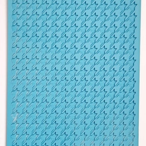 May include: A blue silicone baking mat with a houndstooth pattern. The mat is designed for use with fondant, gum paste, and other edible decorations.
