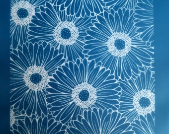 May include: A blue background with a white floral pattern of daisies. The daisies are outlined in white and have a white center with a small blue circle in the center.