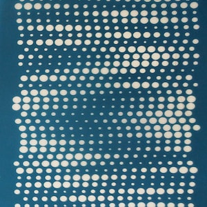 Op de afbeelding: Een tealblauwe stencil met een patroon van witte cirkels in verschillende maten. De stencil heeft het woord "moiko" in wit gedrukt aan de boven- en onderkant.