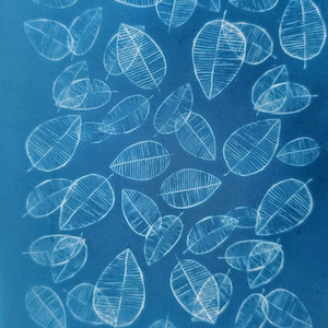 May include: Cyan blue background with white leaf outlines. The leaves are arranged in a random pattern. The text "moiko 11.34" appears in the top left corner. The text "moiko" appears in the bottom right corner.
