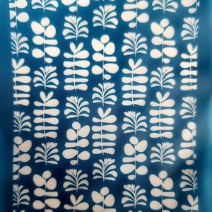 May include: A blue patterned design featuring white stylized plant motifs. The pattern includes various leaf and stem arrangements. The text "moiko 18.06" and "moiko" are visible in the upper left and lower right corners.