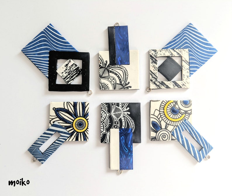 Pu&ograve; includere: Sei ciondoli in ceramica fatti a mano con un design geometrico in bianco e nero e accenti blu. I ciondoli hanno la forma di quadrati e rettangoli e presentano una variet&agrave; di motivi, tra cui spirali, punti e linee.