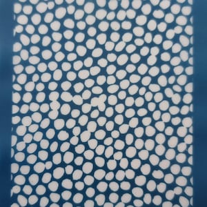 May include: A blue background with a white polka dot pattern. The dots are of varying sizes and are randomly arranged.