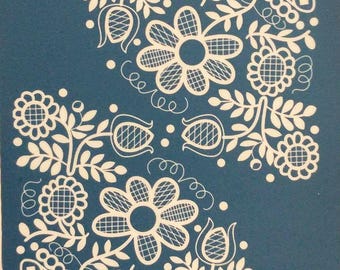 May include: A blue background with a white floral design. The design features stylized flowers, leaves, and decorative elements. The word "moiko" is printed in white in the upper left and lower right corners.