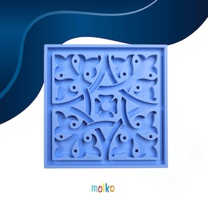 May include: A square, light blue silicone mold with a detailed floral and geometric design. The mold features a central flower-like shape surrounded by interconnected leaf and vine patterns. The word "moiko" is printed in the bottom corner.