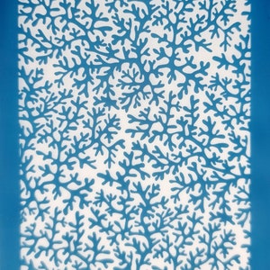 May include: Blue plastic stencil with a white background featuring a repeating pattern of coral branches.