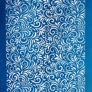 Puede incluir: Una plantilla azul con un intrincado patrón floral blanco. La plantilla tiene el texto "moiko 19.35" en la esquina superior izquierda y "moiko" en la esquina inferior derecha.