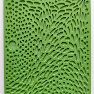 May include: A green, textured, rectangular kitchen mat with a repeating pattern of circles and ovals. The mat has the word "moiko" printed in the top left corner.
