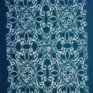 May include: A detailed, symmetrical pattern in white against a deep blue background. The design features ornate, swirling floral and scrollwork motifs, creating a vintage, elegant aesthetic. The word "moiko" is in the upper left and lower right corners.