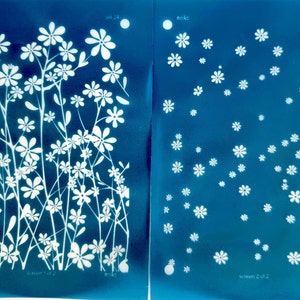 May include: Two cyan blue screens with white floral designs. The left screen has a larger floral design with stems and leaves. The right screen has a smaller, more scattered floral design. The text "screen 1 of 2" is at the bottom of the left screen and "screen 2 of 2" is at the bottom of the right screen.