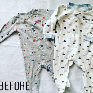 May include: Two long-sleeved footed sleepsuits. The left one is heather grey with a pattern of small baseballs and red and blue shapes, featuring a patch that reads "HAVE A LITTLE FUN". The right one is white with blue elephant prints.