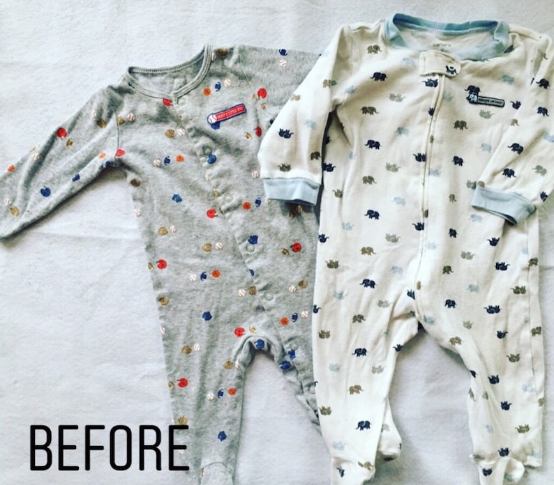 May include: Two long-sleeved footed sleepsuits. The left one is heather grey with a pattern of small baseballs and red and blue shapes, featuring a patch that reads "HAVE A LITTLE FUN". The right one is white with blue elephant prints.