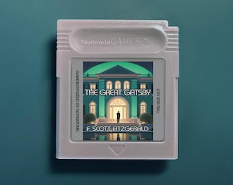 Puede incluir: Un cartucho de videojuego Nintendo Game Boy de color gris claro con una etiqueta personalizada que muestra una ilustración de una mansión y el texto The Great Gatsby de F. Scott Fitzgerald, Gameboynized by Nowintime y This Side Out.