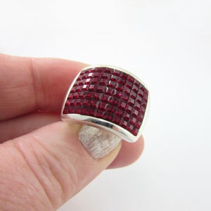 May include: A silver ring with a large, rectangular red gemstone. The gemstone is made up of many small, square-shaped stones.