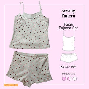 Op de afbeelding: Een witte pyjamaset met rode hartpatronen, bestaande uit een camisole top en shorts. De afbeelding bevat ook een naaipatroon met de tekst "Sewing Pattern Paige Pajama Set" en maatdetails.