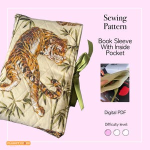 May include: A quilted book sleeve with a tiger design. The cover features a detailed illustration of a tiger in shades of brown and orange against a cream background with bamboo stalks. The text "Sewing Pattern" and "Book Sleeve With Inside Pocket" are also visible.