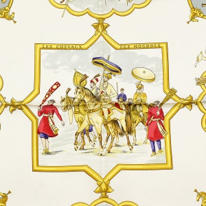 May include: A white background with a gold star shape frame. Inside the frame is a scene of a procession of people on horseback. The people are wearing colorful clothing and turbans. The scene is set against a light blue sky with clouds. The text 'LES CHEVAUX DES MOGHOLS' is written in gold letters at the top of the frame.