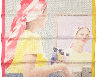 May include: A square silk scarf featuring a pop-art style illustration of a person wearing a pink and white headscarf and a yellow top, looking into a mirror. The border is multicolored with pink, light blue, green, and yellow segments.