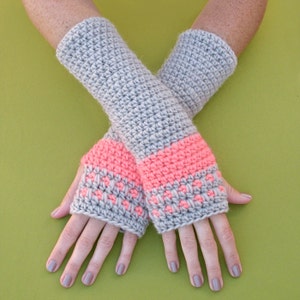 May include: Gray crocheted fingerless gloves with a pink and gray stripe detail.