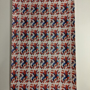 May include: White fabric with a repeating pattern of a red and blue Spiderman character.