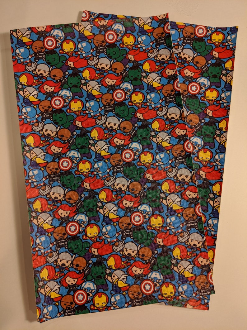 May include: Three sheets of blue fabric with a repeating pattern of small cartoon superheroes. The superheroes include Captain America, Iron Man, Thor, Hulk, Black Widow, Hawkeye, and others. The fabric is perfect for crafting projects like quilting, scrapbooking, and making bags.