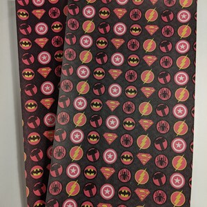 May include: Two sheets of black fabric with a repeating pattern of red circles containing superhero logos. The logos include Batman, Superman, Spiderman, The Flash, and Thor's hammer.