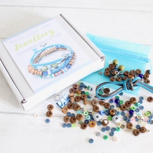 Make your own jewellery friendship bracelet kit. The kit includes a white box with the words 'Make your own jewellery Friendship Bracelet Kit' on the front. The box contains a variety of colorful beads, string, and a blue bag. The kit is perfect for making friendship bracelets.