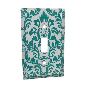 May include: A white light switch cover with a teal damask pattern.