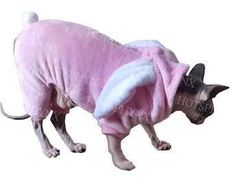 May include: A pink bunny costume for a cat. The costume has a hood with bunny ears and a fluffy tail.