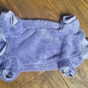 May include: A soft, purple, fuzzy dog sweater with a turtleneck.