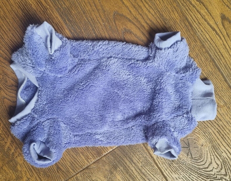 May include: A soft, purple, fuzzy dog sweater with a turtleneck.