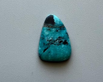 May include: A polished, teardrop-shaped gemstone with a vibrant turquoise hue, accented by black and brown veining. The top portion is a solid black, transitioning into the lighter turquoise. The stone is smooth and appears to be a natural mineral.